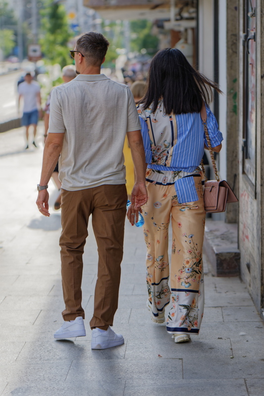 26 - Two individuals strolling down a city street in Bucharest